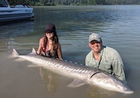 John and client posting for picture with giant sturgeon